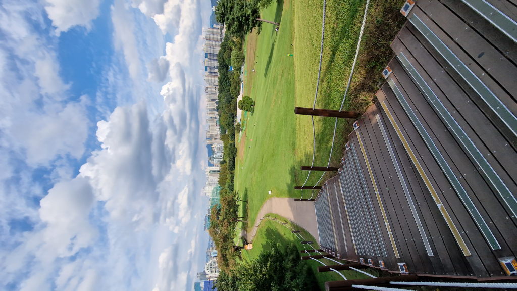 Treppenabgang im Olympic Park mit grüner Wiese und Stadtpanorama