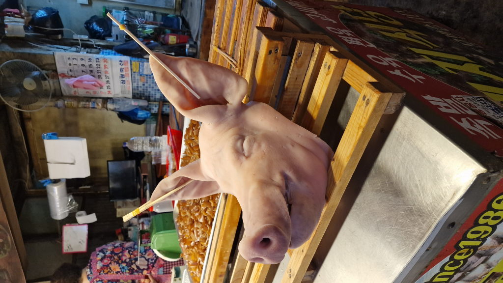 Schweinskopf mit Essstäbchen auf Marktstand in Daegu