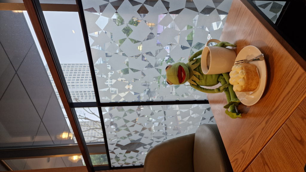 Kermit mit Kaffee und Kuchen im Café Daegu bei Regen