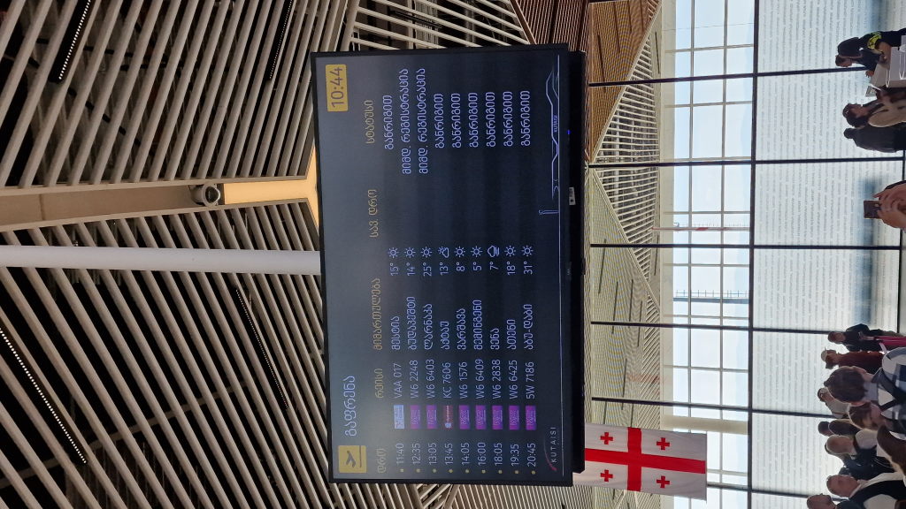 Abflugtafel am Kutaisi International Airport in georgischer Schrift
