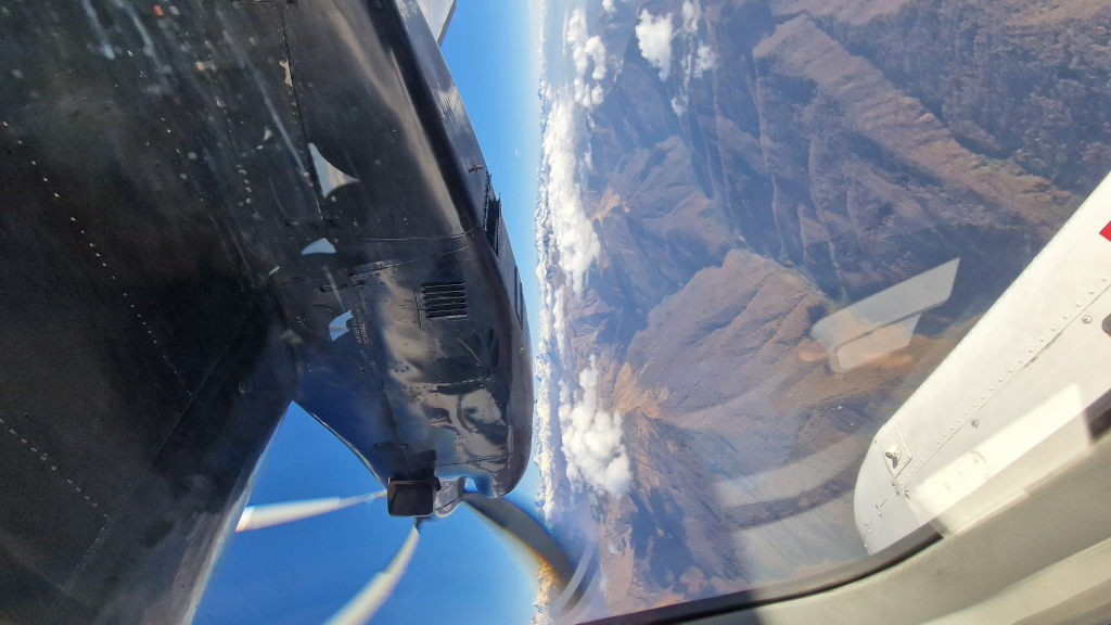 Blick aus Propellermaschinen-Fenster auf Kaukasus-Gebirge mit Schnee