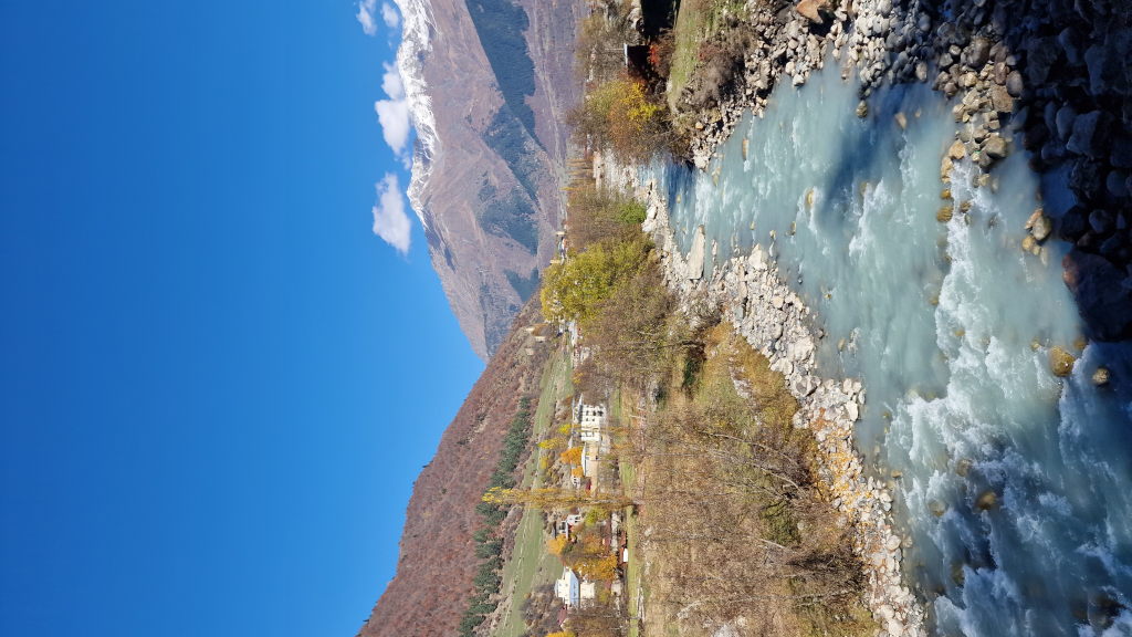Türkiser Gebirgsfluss Enguri im Mestia-Tal mit schneebedeckten Bergen im Hintergrund