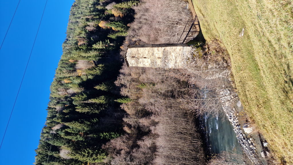 Mittelalterlicher Wehrturm am Gebirgsfluss im Herbstwald