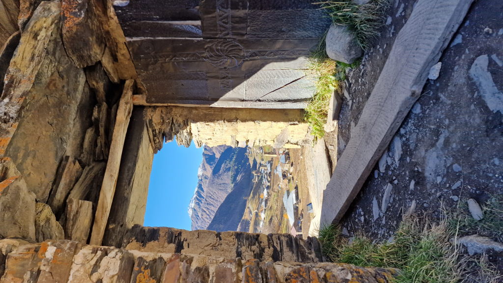 Blick durch altes Steintor auf Ushguli und schneebedeckte Berge
