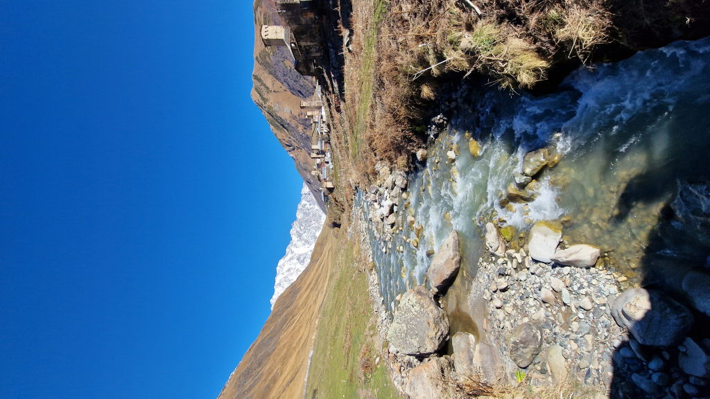 Bach fließt durch Ushguli mit Wehrtürmen und Shkhara-Gletscher
