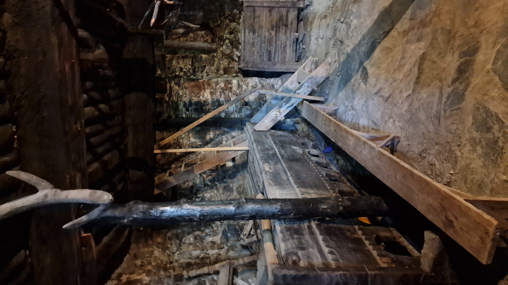 Dunkler Innenraum eines Svan-Wehrturms mit alten Truhen und Geweih