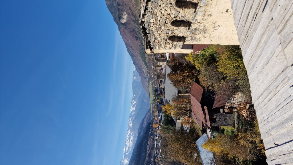 Blick vom Turmdach über Mestia ins Enguri-Tal mit schneebedeckten Bergen