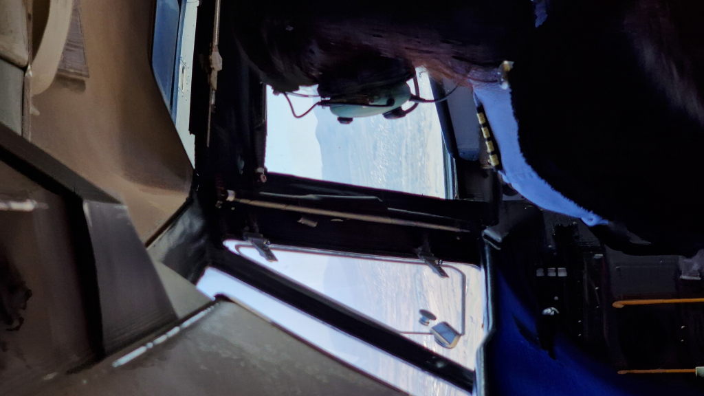 Blick über Schulter der Pilotin ins Cockpit mit Kaukasus-Panorama