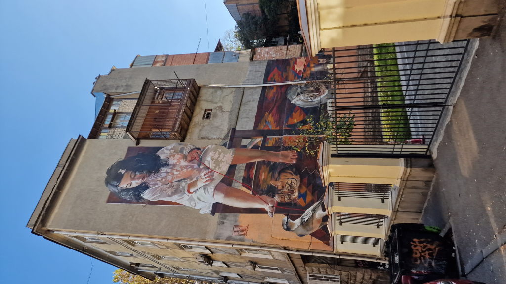 Riesiges hyperrealistisches Wandgemälde mit Mädchen, Katzen und Vogel in Tiflis