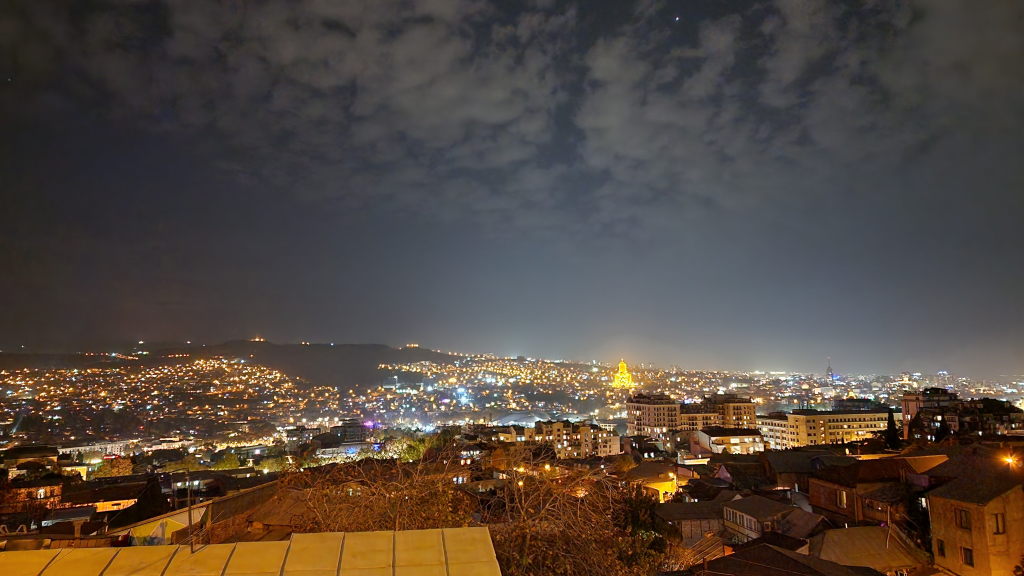 Tiflis bei Nacht mit leuchtender Tsminida Sameba Kathedrale und Stadtpanorama
