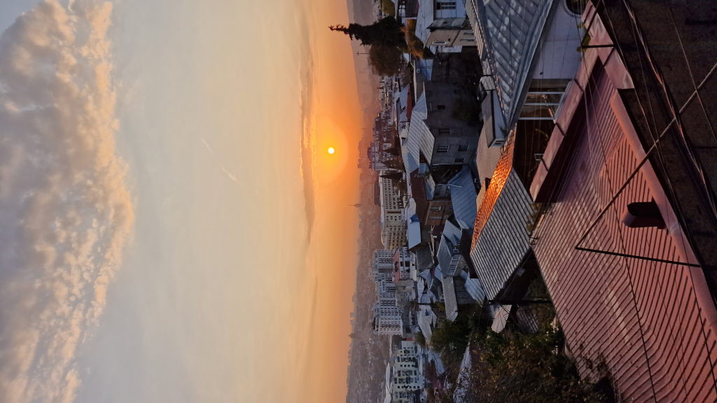 Sonnenaufgang über den Blechdächern von Tiflis in orange-goldenem Licht