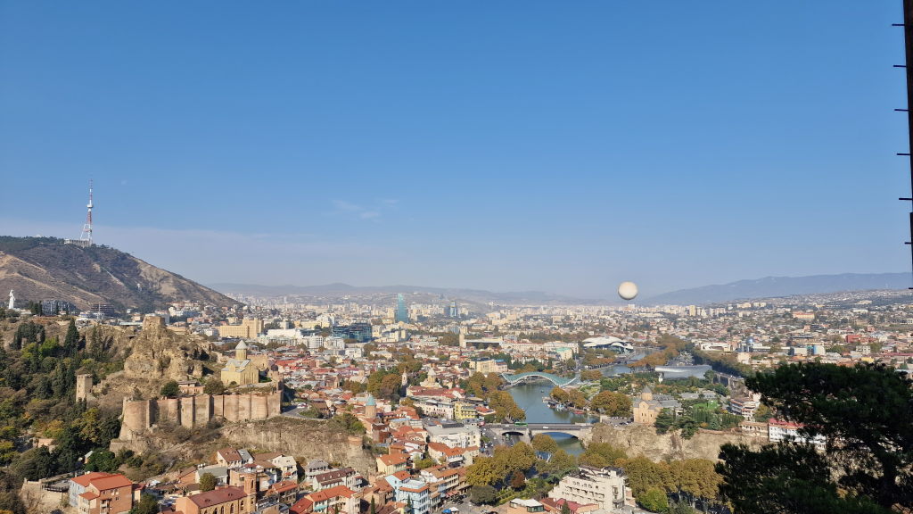 Weitpanorama Tiflis von Narikala mit Narikala-Ruine, Friedensbrücke und Neustadt