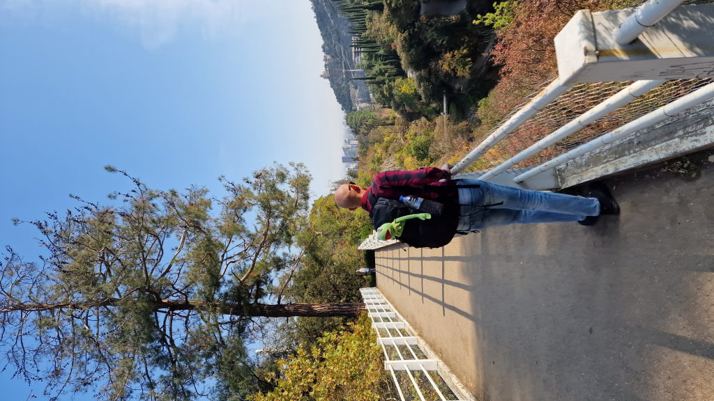 Walter mit Kermit auf dem Rücken auf Brücke über Schlucht in Tiflis
