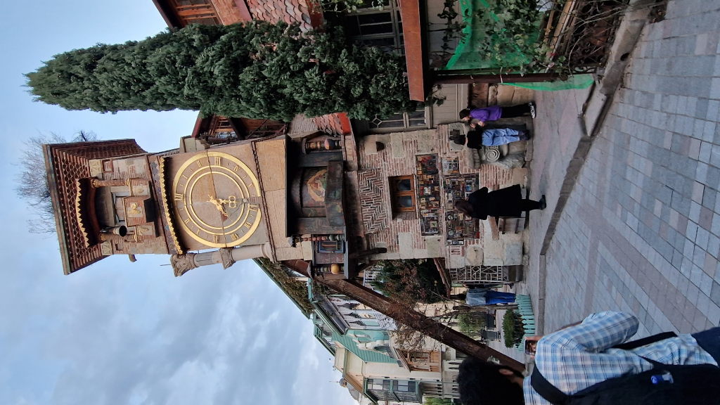 Schiefer Glockenturm mit goldener Uhr beim Rezo-Gabriadze-Theater in Tiflis