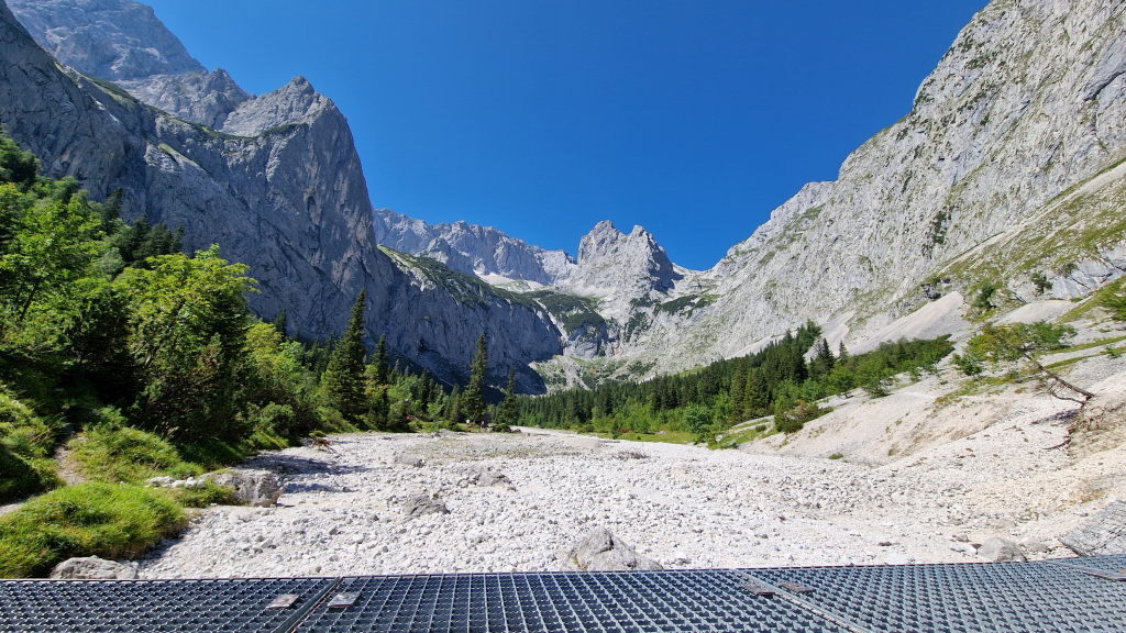 Weites Steintal im Höllental mit steilen Felswänden und blauem Himmel