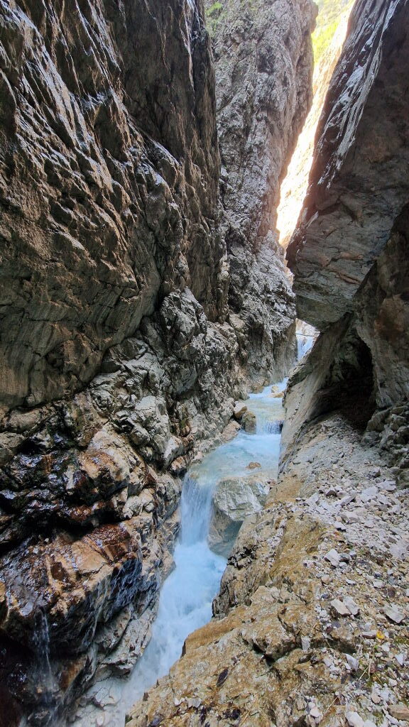 Enge Felsschlucht der Höllentalklamm mit türkisblauem Bach zwischen steilen Felswänden