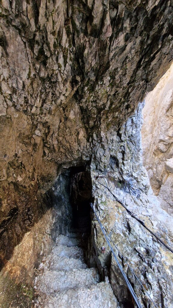 Enger Felstunnel in der Höllentalklamm mit Sicherungsseil an nassen Felsen