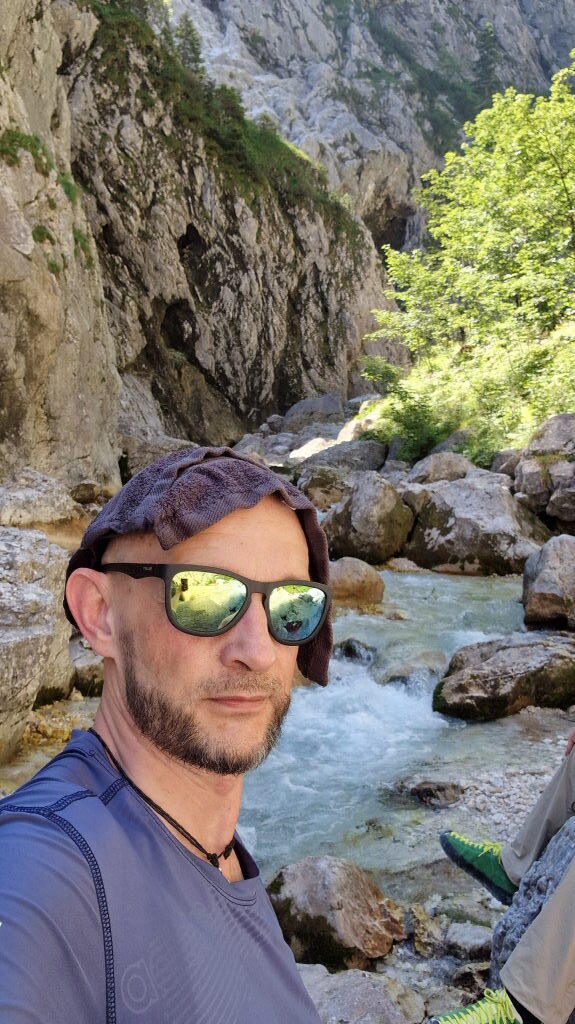 Wanderer mit Sonnenbrille macht Selfie am reißenden Bergbach in der Höllentalklamm