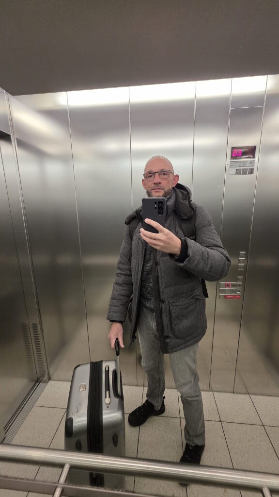 Sebastian Walter mit Koffer im Aufzug am Münchner Hauptbahnhof, Abreise zur Directions EMEA 2025 in Posen