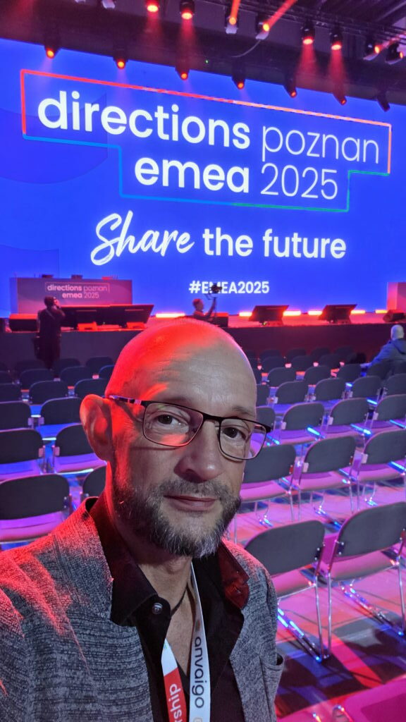 Sebastian Walter Selfie im leeren Konferenzsaal der Directions EMEA 2025 in Posen vor der großen Bühne