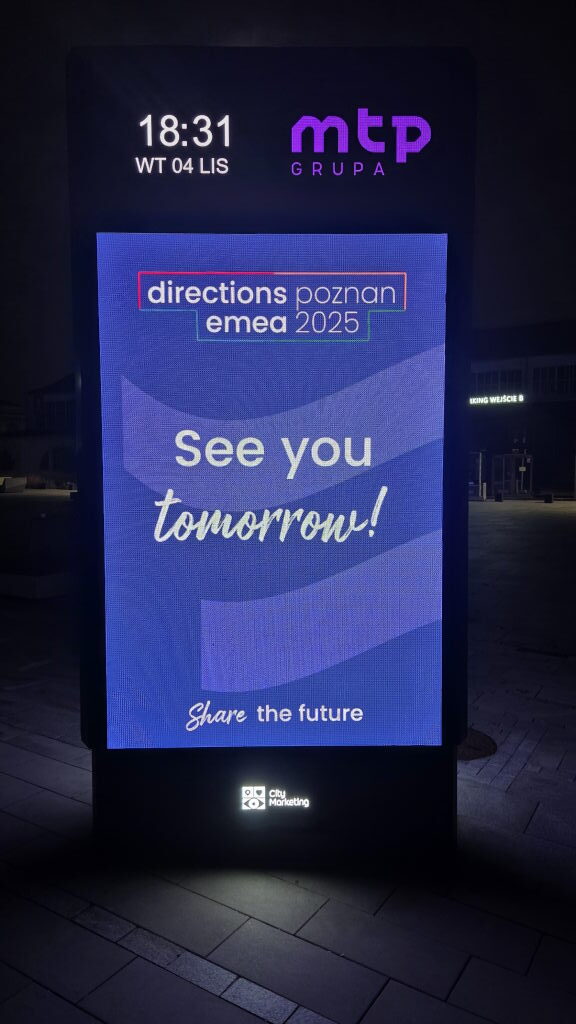 Digitales Stadtmarketing-Schild mit Directions EMEA 2025 Werbung See you tomorrow in Posen bei Nacht